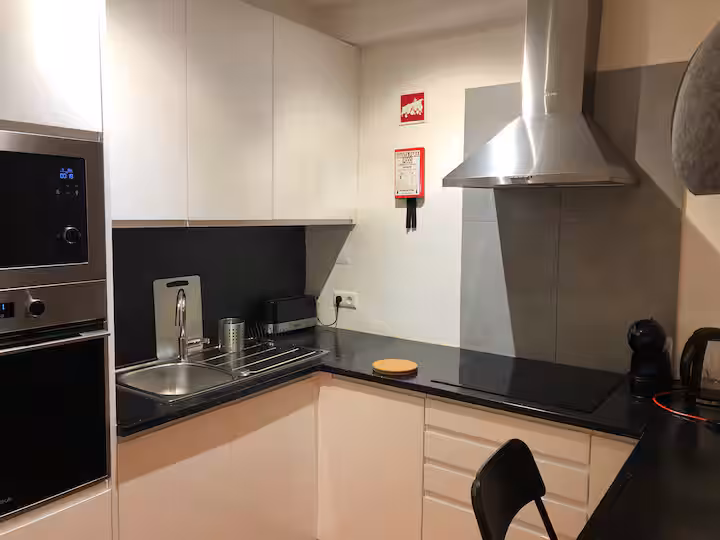 Kitchenette do apartamento com bancada e equipamentos de cozinha